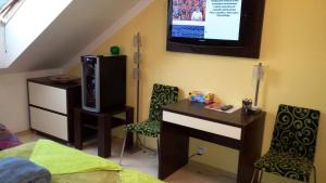 a bedroom with a bed and a tv on the wall at Free Apartman Besenova in Bešeňová