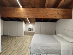 sypialnia z dużym łóżkiem i drewnianym sufitem w obiekcie Il Vico Del Drago w mieście LʼAquila