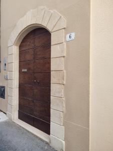 una grande porta di legno sul lato di un edificio di Il Vico Del Drago a L'Aquila