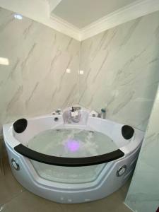 a bathroom with a bath tub with a sink at Ecusuites Riverfront One Vista al Río Jacuzzi Hidro in Guayaquil