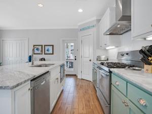 a large kitchen with white cabinets and blue appliances at Blue Starfish in Destin