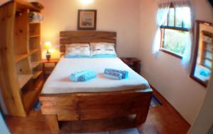 1 dormitorio con 1 cama con 2 velas azules en Chalé Honeycomb em Visconde de Mauá, en Bocaina de Minas