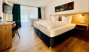 勒芬根的住宿－Landhotel Tanneneck - ideal für Gruppen, Familien und Hunde，酒店客房设有一张大床、一张书桌和一张书桌。