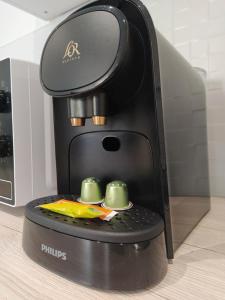 a black coffee maker with two cups on top at Studio 2 in Moirans-en-Montagne