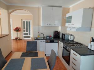 a kitchen with white appliances and a table with chairs at Casa Mario in Oradea +15 photos