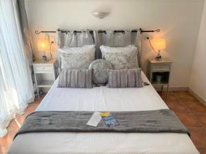 a large bed in a bedroom with two lamps at Hôtel Le Méditerranée in Hyères