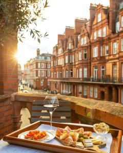 倫敦的住宿－聖多米尼哥別墅酒店，盘子上放着一盘食物和一杯葡萄酒