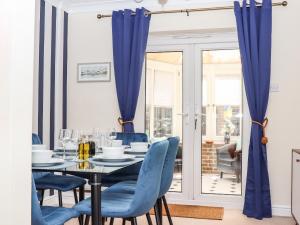 a dining room with a table and blue chairs at Regatta Haus in Eastbourne