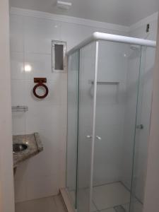 y baño con ducha de cristal y lavabo. en Apartamento Balneário Camboriú - 2 quartos 80m do mar, en Balneário Camboriú