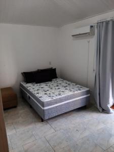 una cama sentada en una habitación junto a una pared en Apartamento Balneário Camboriú - 2 quartos 80m do mar, en Balneário Camboriú