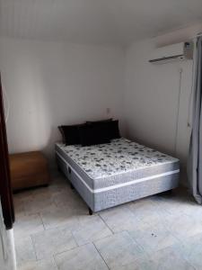 una cama sentada en una habitación junto a una pared en Apartamento Balneário Camboriú - 2 quartos 80m do mar, en Balneário Camboriú