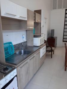 cocina con fregadero y fogones en Apartamento Balneário Camboriú - 2 quartos 80m do mar, en Balneário Camboriú