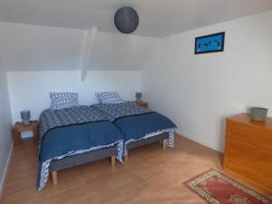 um quarto com uma cama com um edredão azul em gite de kerveg em Bégard