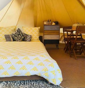 a bedroom with a bed and a table in a tent at Kawaida - Hébergement insolite - Glamping Makazi in Sainte-Luce