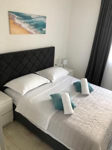a bedroom with a bed with two pillows on it at Apartman MIR in Makarska
