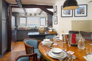 a kitchen with a wooden table with chairs and a dining room at 3 Bed - Smugglers Cottage in Torquay