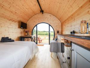 een slaapkamer in een houten hut met een bed bij Stargaze in Truro