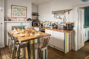 a kitchen with a long wooden table with chairs at Coastguards Lookout in Camber