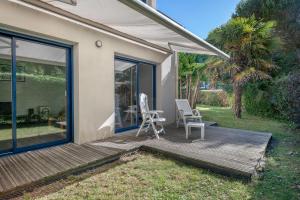 a deck with two chairs and a table on it at À 200m du Port de Crouesty, Maison 6 personnes in Arzon