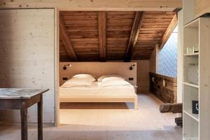 Łóżko w pokoju z drewnianym sufitem w obiekcie Hotel Strobl w mieście Sesto