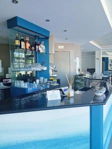 un bar dans un restaurant avec un comptoir bleu dans l'établissement Hotel Alb's, à Alba Adriatica