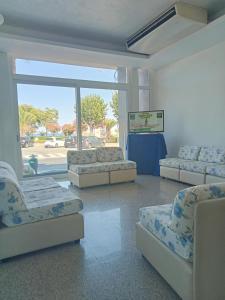 um quarto com sofás e cadeiras num quarto com uma janela em Hotel Alb's em Alba Adriatica