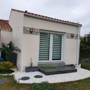 una casa blanca con una puerta delantera y un patio en Appartement EVR!CA - 1 place parking gratuit, en Le Perrier