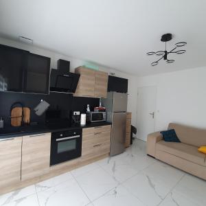 sala de estar con cocina y sofá en Appartement EVR!CA - 1 place parking gratuit, en Le Perrier