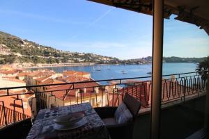 a balcony with a table and a view of a harbor at Excellent location - Sea Views in Villefranche-sur-Mer