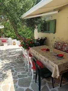 a table and chairs with flowers on a patio at Arhondia House in Ierápetra