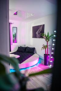 a bedroom with a bed with pink and purple lights at Apartment de Lux Craiova Jacuzzi Pat Rotund Semineu Zona Ford in Craiova