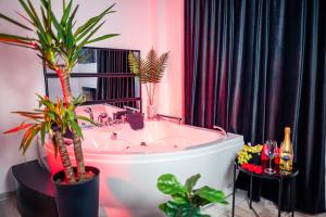 a bathroom with a bath tub with potted plants at Apartment de Lux Craiova Jacuzzi Pat Rotund Semineu Zona Ford in Craiova