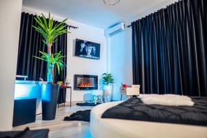 una camera da letto con tende nere, un letto e un camino di Apartment de Lux Craiova Jacuzzi Pat Rotund Semineu Zona Ford a Craiova