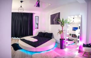 a pink and black bedroom with a bed in a room at Apartment de Lux Craiova Jacuzzi Pat Rotund Semineu Zona Ford in Craiova