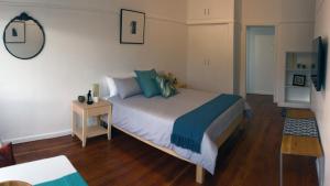 1 dormitorio con 1 cama grande con almohadas azules en Studio 5 Milford House, en Ciudad del Cabo