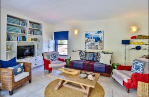 een woonkamer met een bank, stoelen en een tafel bij Mediterranean beach villa - FAMILIES ONLY in Ballito