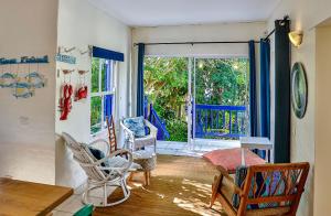 een woonkamer met stoelen en een groot raam bij Mediterranean beach villa - FAMILIES ONLY in Ballito
