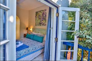 een klein balkon met een bed en een raam bij Mediterranean beach villa - FAMILIES ONLY in Ballito +33 foto's