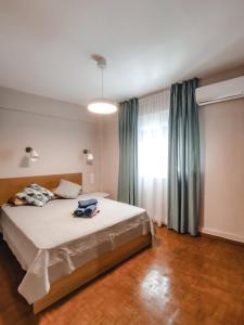 a bedroom with a large bed and a window at TIP TOP apartment in Chalkida