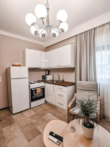 eine Küche mit weißen Schränken und einem Tisch in der Unterkunft TIP TOP apartment in Chalkida