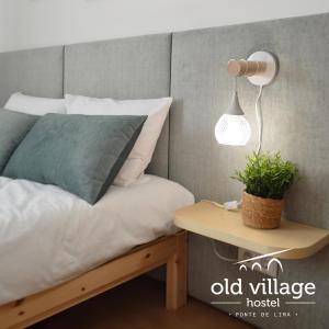a bedroom with a bed and a table with a lamp at Oldvillage Hostel in Ponte de Lima
