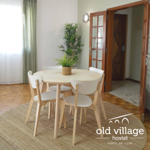 einen Holztisch und Stühle in einem Zimmer in der Unterkunft Oldvillage Hostel in Ponte de Lima