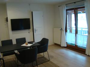 a dining room with a table and chairs and a television at Schöne Ferienwohnung im Nationalpark nördlicher Schwarzwald in Forbach