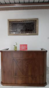 a picture hanging on a wall above a wooden cabinet at House of A Syariah Sukarame in Tanjungkarang