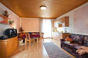 ein Wohnzimmer mit einem Sofa und einem Tisch in der Unterkunft Appartements Hartlbauer in Dorfgastein