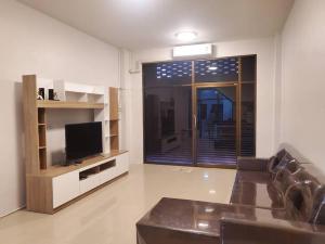 uma sala de estar com um sofá, uma televisão e uma janela em Khoksametchun Hostel Plus 2 em Hat Yai