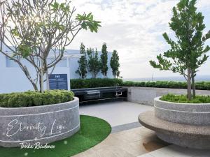 a garden with two trees in two concrete pots at Eternity Live3@Troika Residence Kota Bharu-2BR8pax in Kota Bharu