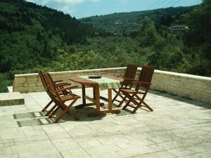 stół i krzesła na patio z widokiem w obiekcie Villa Ermis w mieście Lákka