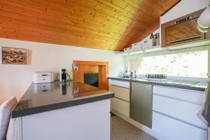 ベットマーアルプにあるDon Giovanniの白いカウンターと木製の天井が備わるキッチン