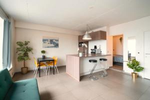 ein Wohnzimmer mit einer Küche mit einer Theke und Stühlen in der Unterkunft Aspen Lodge in the Center of Antwerp in Antwerpen